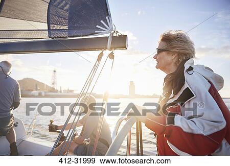 Woman sailing steering sailboat at helm on sunny ocean View Large Photo Image Stock Photo - Woman sailing steering sailboat at helm on sunny ocean. Fotosearch