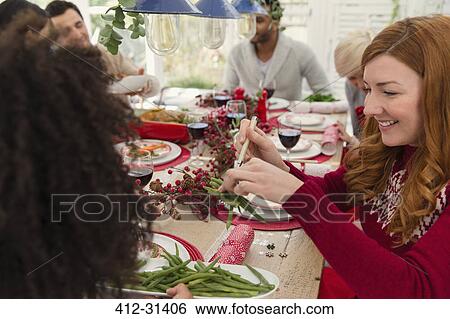 Woman serving green beans at Christmas dinner View Large Photo Image Stock Photograph - Woman serving green beans at Christmas dinner. Fotosearch