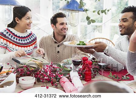 Stock Image - Woman serving turkey at Christmas dinner. Fotosearch