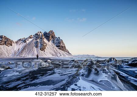 Woman standing among remote, icy landscape, Hofn, Iceland View Large Photo Image Stock Photo - Woman standing among remote, icy landscape, Hofn, Iceland. Fotosearch