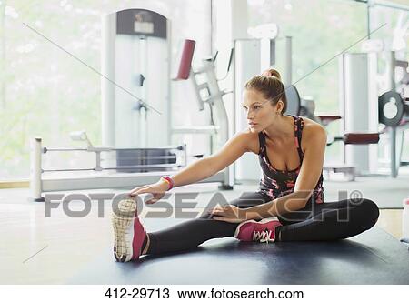 Woman stretching leg at gym View Large Photo Image Stock Image - Woman stretching leg at gym. Fotosearch