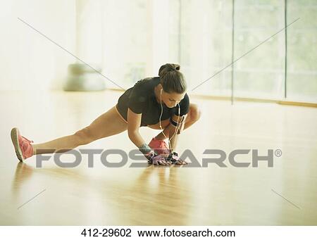 Stock Image - Woman stretching leg in gym studio. Fotosearch