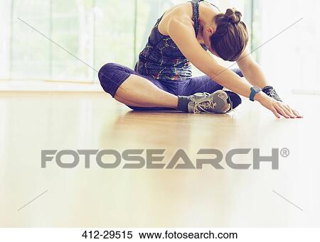 Woman stretching on gym studio floor View Large Photo Image Stock Photography - Woman stretching on gym studio floor. Fotosearch