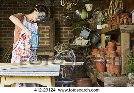 Woman using power sander in workshop View Large Photo Image Picture - Woman using power sander in workshop. Fotosearch