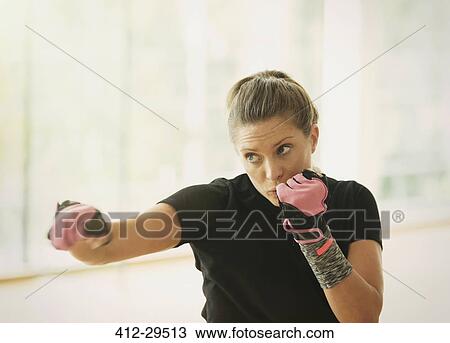 Woman with exercise gloves shadow boxing View Large Photo Image Stock Image - Woman with exercise gloves shadow boxing. Fotosearch