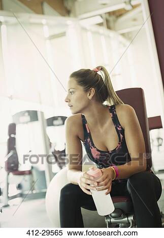 Woman with water bottle resting at gym View Large Photo Image Stock Photography - Woman with water bottle resting at gym. Fotosearch