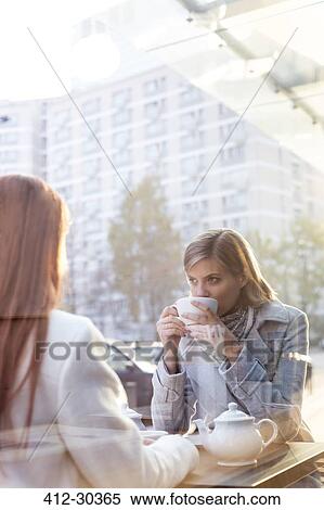 Stock Photography - Women drinking tea at sidewalk cafe. Fotosearch