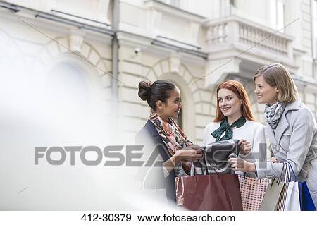 Women with shopping bags looking at scarf View Large Photo Image Stock Photo - Women with shopping bags looking at scarf. Fotosearch