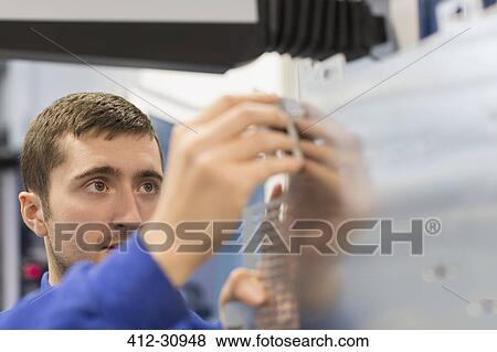 Stock Photo - Worker checking steel in steel factory. Fotosearch