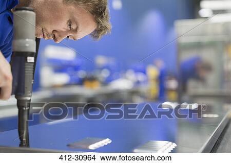 Worker drilling steel in steel factory View Large Photo Image Picture - Worker drilling steel in steel factory. Fotosearch