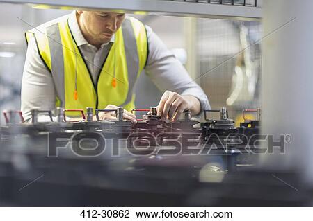 Worker examining machinery in steel factory View Large Photo Image Stock Image - Worker examining machinery in steel factory. Fotosearch