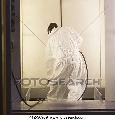 Stock Photo - Worker in clean suit in steel factory. Fotosearch