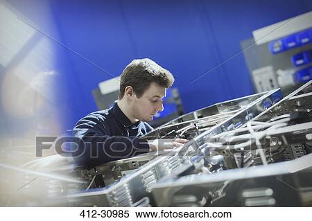 Stock Photography - Worker inspecting machinery in steel factory. Fotosearch