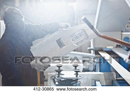 Worker lifting piece in steel factory View Large Photo Image Stock Photography - Worker lifting piece in steel factory. Fotosearch