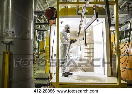 Stock Photograph - Worker operating machinery in factory. Fotosearch