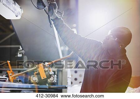Worker operating machinery in steel factory View Large Photo Image Picture - Worker operating machinery in steel factory. Fotosearch