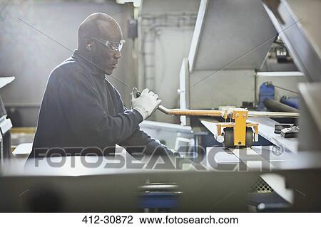 Worker operating machinery in steel factory View Large Photo Image Stock Image - Worker operating machinery in steel factory. Fotosearch