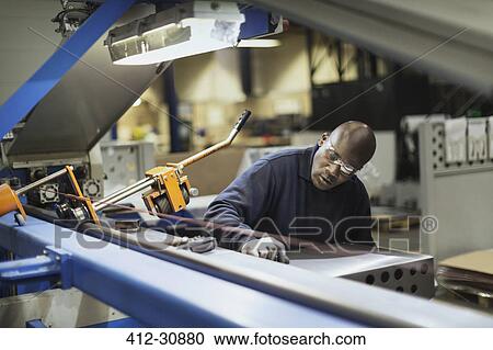Worker operating machinery in steel factory View Large Photo Image Stock Image - Worker operating machinery in steel factory. Fotosearch