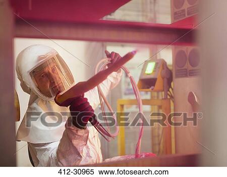 Stock Photography - Worker painting steel red in steel factory. Fotosearch