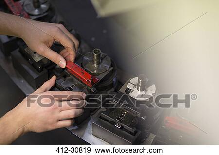 Stock Photo - Worker preparing machine in steel factory. Fotosearch