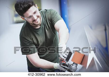 Worker sanding steel in steel factory View Large Photo Image Stock Image - Worker sanding steel in steel factory. Fotosearch