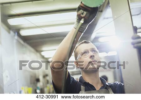 Worker sanding steel in steel factory View Large Photo Image Stock Image - Worker sanding steel in steel factory. Fotosearch