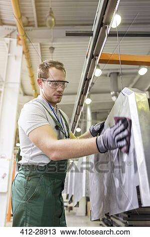 Worker sanding steel part in factory View Large Photo Image Stock Image - Worker sanding steel part in factory. Fotosearch