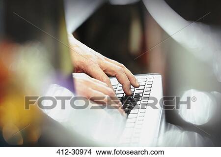 Picture - Worker typing on computer keyboard in steel factory. Fotosearch