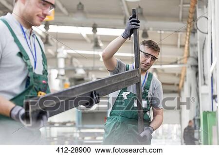 Workers carrying part in factory View Large Photo Image Stock Image - Workers carrying part in factory. Fotosearch