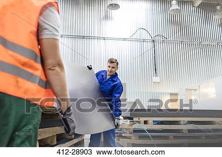 Workers carrying sheet metal in factory View Large Photo Image Stock Image - Workers carrying sheet metal in factory. Fotosearch