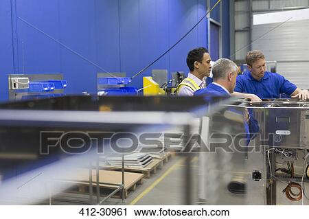 Workers examining equipment in steel factory View Large Photo Image Stock Image - Workers examining equipment in steel factory. Fotosearch