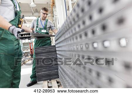 Workers lifting steel parts in factory View Large Photo Image Stock Image - Workers lifting steel parts in factory. Fotosearch