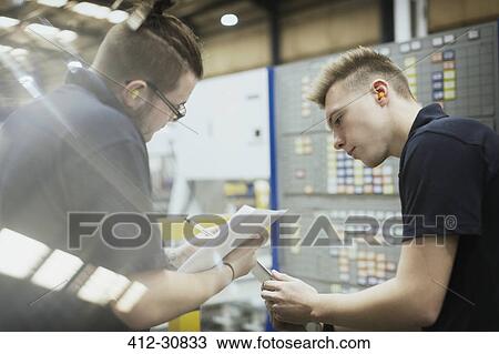 Workers meeting with paperwork in steel factory View Large Photo Image Stock Image - Workers meeting with paperwork in steel factory. Fotosearch