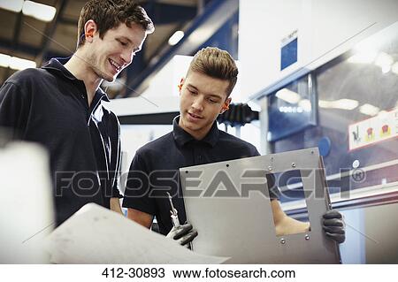Workers reviewing paperwork in steel factory View Large Photo Image Stock Image - Workers reviewing paperwork in steel factory. Fotosearch