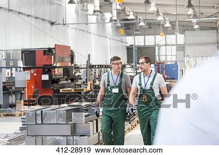 Stock Photo - Workers walking and talking in factory. Fotosearch