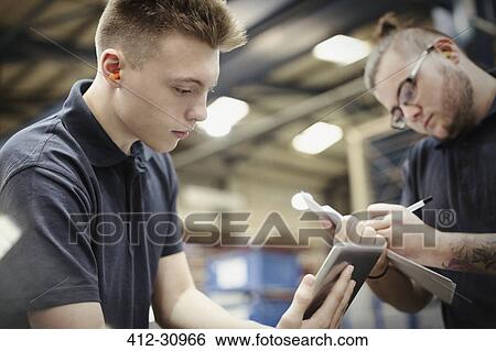 Workers with paperwork and digital tablet in steel factory View Large Photo Image Stock Photograph - Workers with paperwork and digital tablet in steel factory. Fotosearch