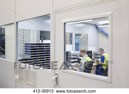 Stock Image - Workers working at computers in steel factory office. Fotosearch