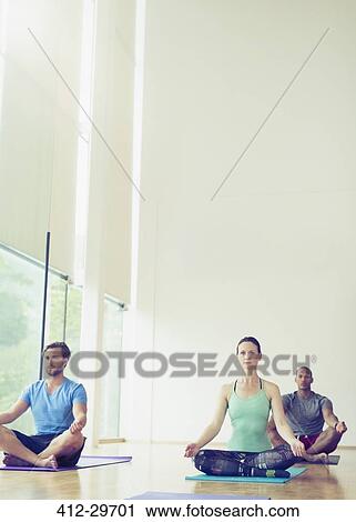 Yoga class sitting in lotus position View Large Photo Image Stock Image - Yoga class sitting in lotus position. Fotosearch