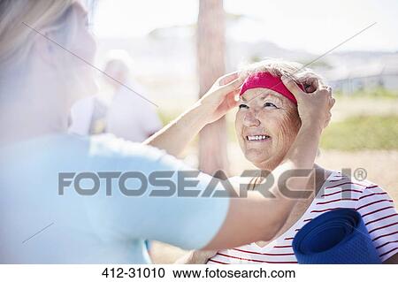 Yoga instructor adjusting senior womans headband View Large Photo Image Stock Image - Yoga instructor adjusting senior womans headband. Fotosearch