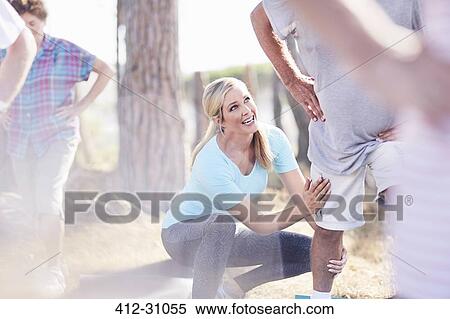 Stock Photography - Yoga instructor guiding senior man in park. Fotosearch