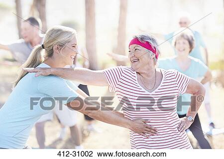 Yoga instructor helping senior woman View Large Photo Image Stock Image - Yoga instructor helping senior woman. Fotosearch