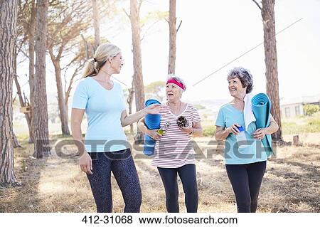 Yoga instructor talking to senior women after yoga class in park View Large Photo Image Stock Photo - Yoga instructor talking to senior women after yoga class in park. Fotosearch