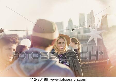 Young adult woman enjoying rooftop party View Large Photo Image Stock Photo - Young adult woman enjoying rooftop party. Fotosearch