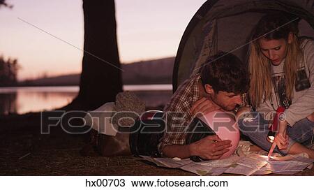 Young couple looking at maps in camping tent View Large Photo Image Stock Image - Young couple looking at maps in camping tent. Fotosearch