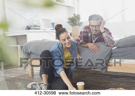 Stock Photo - Young couple relaxing in apartment bedroom. Fotosearch