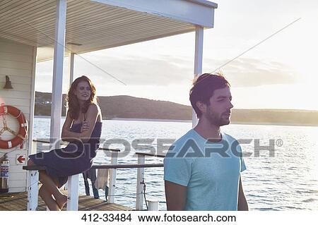 Picture - Young couple relaxing on summer houseboat. Fotosearch