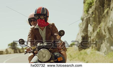 Young couple riding motorcycle on sunny road View Large Photo Image Stock Image - Young couple riding motorcycle on sunny road. Fotosearch