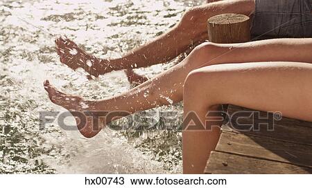 Young couple splashing bare feet in lake View Large Photo Image Stock Image - Young couple splashing bare feet in lake. Fotosearch