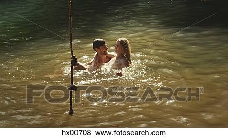 Stock Photo - Young couple swimming in sunny lake. Fotosearch