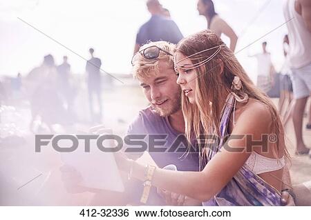 Young couple using digital tablet at poolside party View Large Photo Image Stock Photograph - Young couple using digital tablet at poolside party. Fotosearch